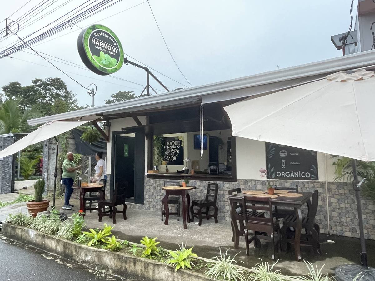 Terraza cubierta del restaurante con mesas de madera