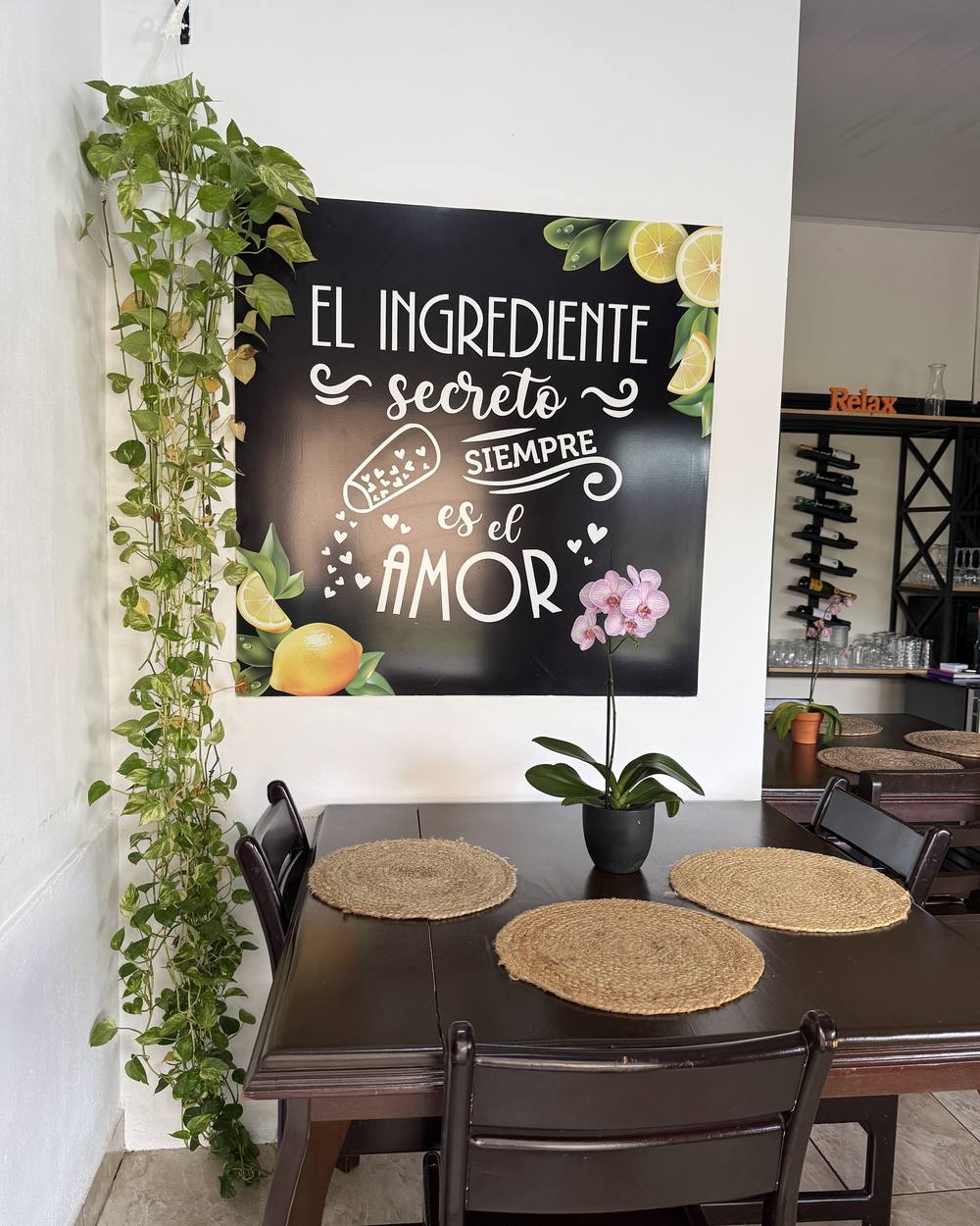 Interior del restaurante con pizarra de menú y plantas